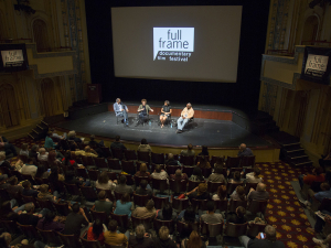 Four panelists speak on stage in front of an audience at the Full Frame festival.