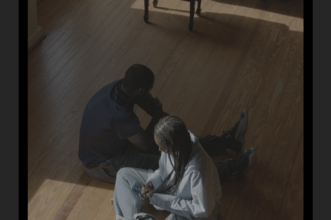 Knight and her cousin sit in a room partly illuminated by window light.