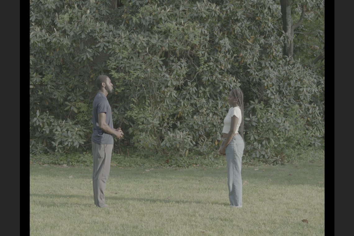 Knight and her cousin face each other in a field of green grass.